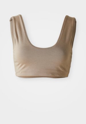 Brassière en tissu beige avec une texture lisse, dotée d'un large décolleté arrondi et de larges bretelles. Pas de matériel visible ni de motifs.