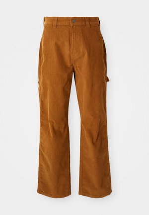 Smeđa kordura hlače s dizajnom proširenih nogavica, s bočnim džepovima i prednjim zatvaranjem na gumb. Tekstura je meka i rebrasta.