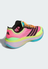 Chaussure de sport rose vif avec empeigne en mesh, rayures noires et accents en vert et bleu. Présente des lacets orange et une semelle multicolore.
