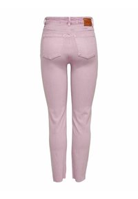 Jean en denim rose clair avec une coupe ajustée, doté d'une taille mi-haute, d'un style cinq poches et d'une étiquette en cuir de marque à l'arrière de la ceinture.