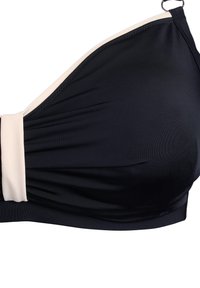 Juodas bikini viršus su grietinėlių akcentais, pasižymintis lygiu tekstūru, surinkta medžiaga ir reguliuojamomis petnešėlėmis, leidžiančiomis pritaikyti tinkamumą.
