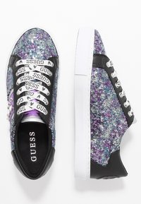 Sneakers scintillanti con una tomaia in paillettes viola, argento e nero, con lacci bianchi e una soletta nera con logo. Suola in gomma bianca.