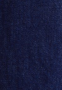 Mørkeblå denimstof med en subtil tekstur, der har et ensartet væv og let variation i nuancerne over overfladen.