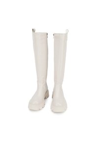Las botas de cuero blancas hasta la rodilla cuentan con una textura suave, un diseño recto, suela de goma plana y cremalleras laterales para facilitar su uso.
