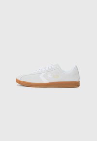 White suede sneakers with a gum sole. Features a white star logo and "ALL STAR" in gold on the side. Rounded toe and lace-up design.