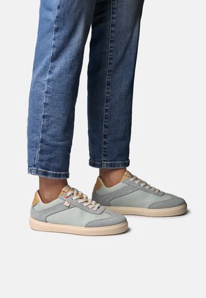 Light grey canvas sneakers with tan leather accents, round toe, and beige sole. Laces are light beige, featuring a side logo detail.
