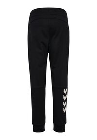 Zwarte sweatpants met een taperende pasvorm, elastische tailleband en witte chevronaccent op het linkerpijp. Zachte stof met een gladde textuur.