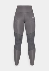 Szürke sportleggings magas derékkal, panel kiemelésekkel, oldalsó zsebekkel és egy logóval a bal felső oldalon.