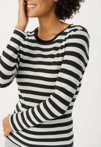 Langarmshirt in Schwarz und cremefarbenen Streifen, mit einem gerippten Hals- und Ärmelbund, aus einem weichen, strukturierten Stoff gefertigt.