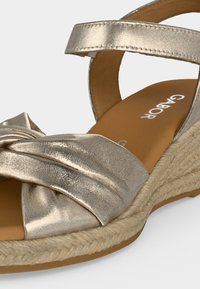 Ασημί μεταλλικό σανδάλι με σφήνα, λουράκι στον αστράγαλο, στριφτό μπροστινό λουράκι, πλεκτή σόλα από τρίχινο σχοινί και ταμπά εσωτερική σόλα με τη σήμανση «Gabor».