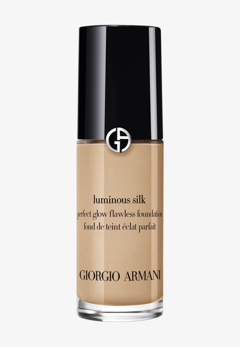 Clear glass bottle of Giorgio Armani Luminous Silk foundation with black cap and silver logo on cap and beige liquid inside.