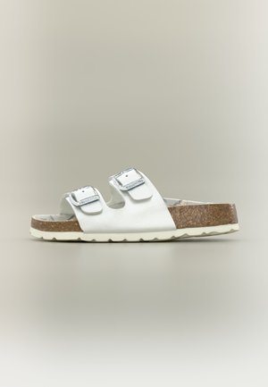 White sandal with two silver buckles, cork sole, and textured off-white bottom, shown in profile on a neutral background.