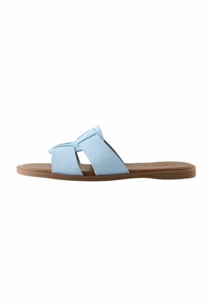 Light blue suede slide sandal with two crossing straps and a flat tan sole. Features a soft texture and minimalistic design.