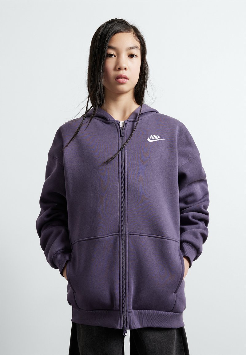 Ljubičasti dukserica sa zipped zatvaranjem, izrađena od mekanog materijala, s prednjim patentnim zatvaračem, dva džepa i malim bijelim Nike logom na prsima.