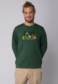Groene sweatshirt met een grafisch ontwerp en de tekst "HAPPY CAMPER" en kampeersymbolen, gemaakt van zachte stof met lange mouwen.