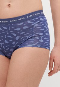 Kék mintás boxer alsó, sima anyagból, széles, "BJÖRN BORG" felirattal domborított rugalmas derékkal. Alakja testhez simuló.
