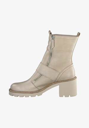 Beige leather ankle boot with side zipper, strap across the front, textured sole, and block heel.