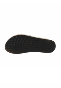 Suola di scarpa in gomma nera con superficie texturizzata, punta arrotondata e sottile bordo beige. Presenta un'impronta di logo circolare vicino al tallone.