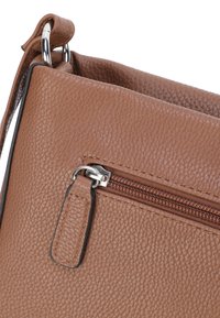 Braune, strukturierte Lederhandtasche mit Reißverschluss, silbernem Hardware und einem kleinen Stoffetikett. Sie verfügt über ein minimalistisches Design und eine strukturierte Form.