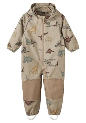 Beiger Kinder-Overall mit Dinosaurier-Motiven. Verfügt über einen Reißverschluss vorne, elastische Bündchen und verstärkte beigefarbene Flicken an den Knien.