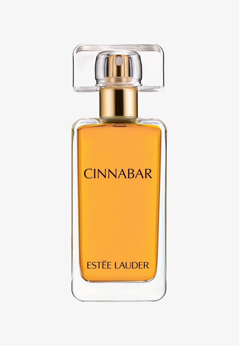 Kvadratisk glasparfymflaska med ett transparent lock, som innehåller bärnstensfärgad vätska. Har fet svart text som står "CINNABAR" och "ESTÉE LAUDER."