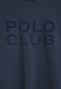 Mörkblå bomull t-shirt med stor, mörkblå "POLO CLUB" text på framsidan. Mjuk känsla med rundad hals.