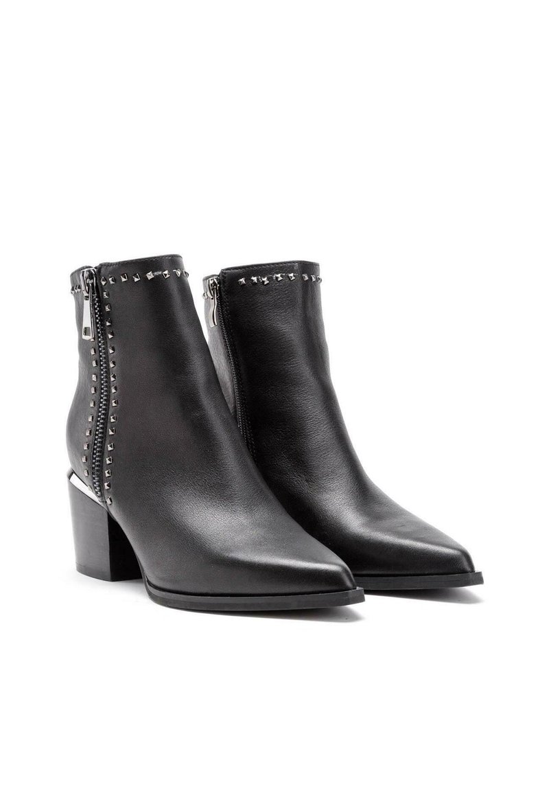 Botas negras de cuero hasta el tobillo con punteras puntiagudas, cremallera plateada y acentos de tachuelas a lo largo del caño. Tacón grueso para mayor estabilidad.