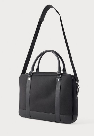 Melna strukturēta soma ar diviem rokturiem un regulējamu siksnu. Izgatavota no gluda materiāla, rotāta ar kontrastējošiem faktūras akcentiem un sudraba krāsas metāla detaļām.