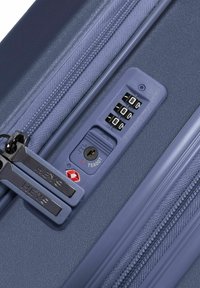 Marineblauer Koffer mit Ecken, dualen Reißverschlüssen, TSA-Schloss und Kombinationsdials. Strukturiert Oberfläche, robuste Hardware und präzise Designdetails.