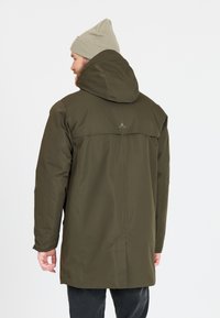 Olijfgroene waterdichte jas heeft een capuchon, zijzakken en een strak design met een rugpand en logo-detail bij de hals.