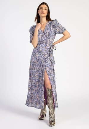 Maxi-jurkje van paarse en blauwe patroonstof met puffmouwen, wikkelontwerp, een voorkant split en gecombineerd met metallic zilveren kniehoge laarzen.