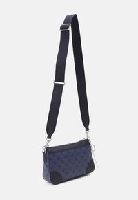 Petit sac à épaule en tissu bleu foncé avec un motif, accents en cuir lisse, quincaillerie argentée et une bandoulière réglable.