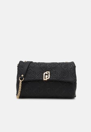 Sort struktureret læderclutch med guldkæde-strap og dekorativt guldlås på ensartet lyst baggrund.