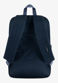 Námornícky modrý ruksak s sieťovinou a textúrovaným panelom, ktorý má polstrované ramenné popruhy a označenie loga po boku.