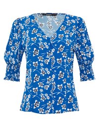 Blusa blu con un motivo floreale in bianco e nero. Presenta un collo a V, una chiusura con bottoni nella parte anteriore e maniche a sbuffo con polsini arricciati.