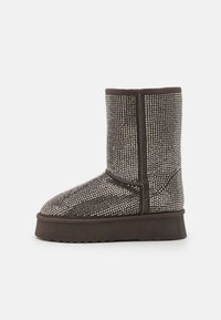 Brune ankelstøvel med teksturert overdel med rutenettmønster og solid gummisåle. Designet inkluderer forsterkede sømmer og rund tå.