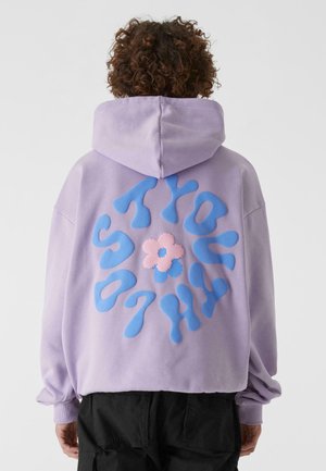 Felpa viola con un ampio design grafico blu e rosa sul retro. Presenta un cappuccio con cordino e polsini a coste, realizzata in tessuto morbido.