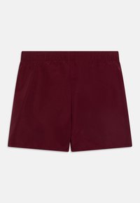 Bañador burdeos hecho de material ligero, con cintura elástica y textura suave, con un diseño simple y sin detalles adicionales.