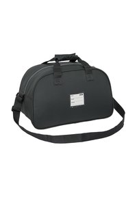 Czarna, miękka torba sportowa z podwójnymi uchwytami, regulowanym paskiem na ramię i przezroczystą etykietą identyfikacyjną na przednim panelu.