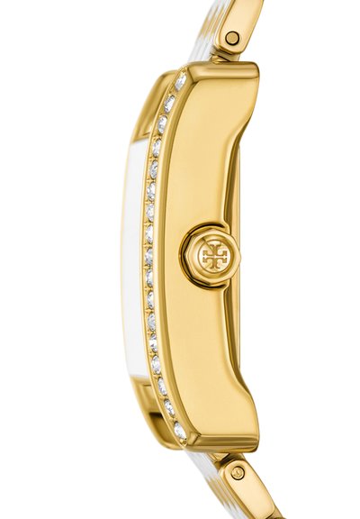 Vue latérale d'une montre en or avec une rangée de diamants le long du bord et un bouton de couronne marqué sur le boîtier.