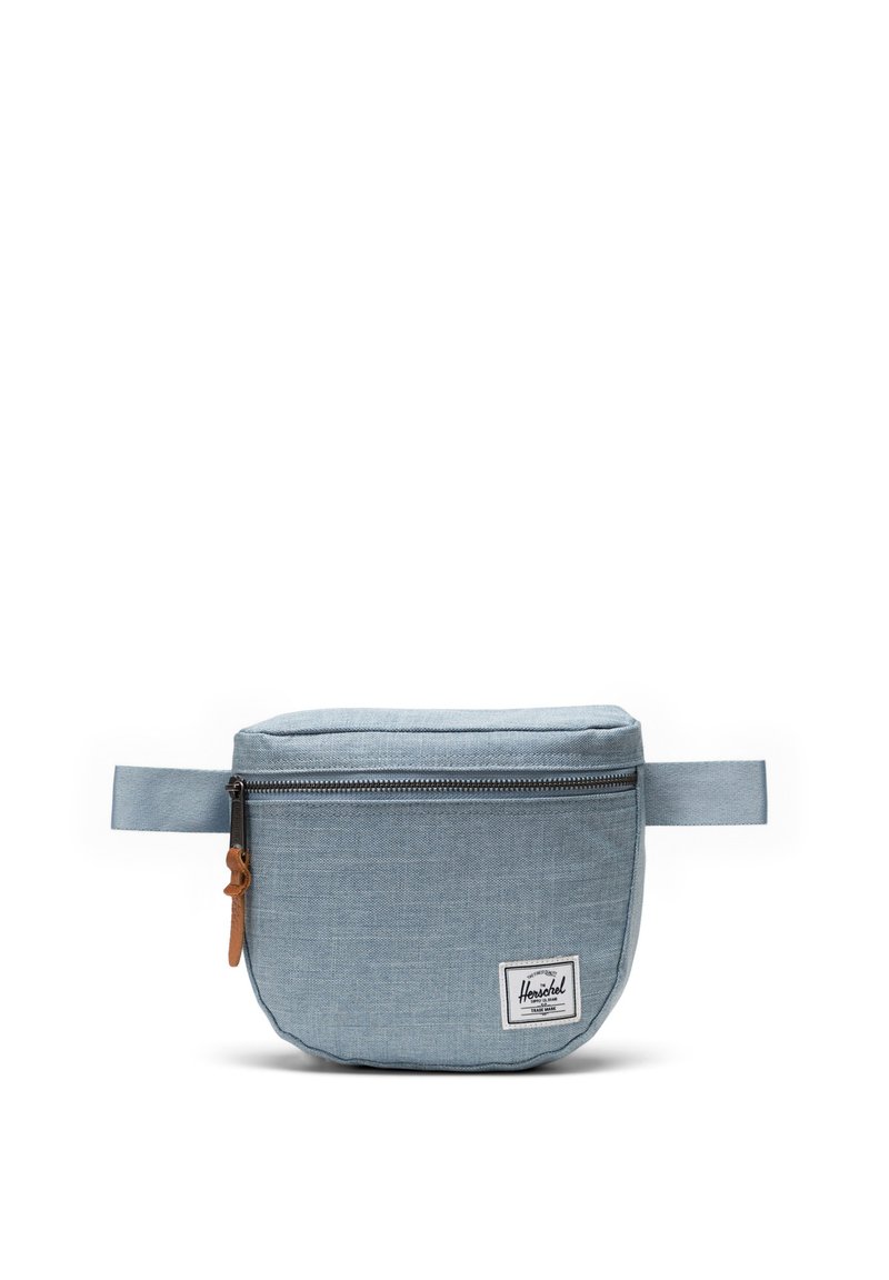 Sacchetto in tessuto azzurro chiaro con zip, dotato di un’etichetta in pelle e un piccolo logo bianco. Design compatto e arrotondato con manico laterale.