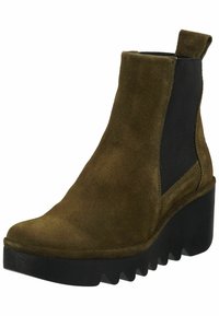 Stivale alla caviglia in suede verde oliva con pannello laterale elasticizzato nero e suola a zeppa caratterizzata da un motivo zigzag. Texture liscia, design elegante.