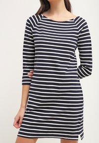Abito a maniche lunghe a righe blu navy e bianche con scollo a barca, caratterizzato da una vestibilità comoda e fessure laterali vicino all'orlo. Realizzato in morbido cotone.