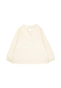 Kremowa bluzka z długim rękawem, z elastycznymi mankietami i małym otworem w kształcie klucza z tyłu przy dekolcie, zdobiona falbaniastym wykończeniem.