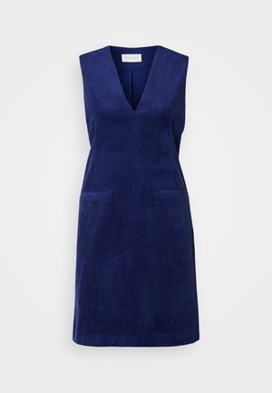 Tengerészkék kordbársony ruha V-kivágással, ujjatlan kivitelben és két elülső zsebbel. Texturált anyag, egyenes sziluett.