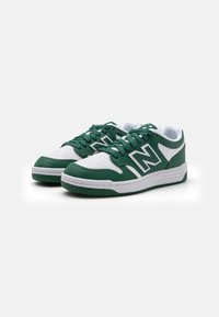 Sneaker verde e bianche con punta forata, tomaia in pelle testurizzata, lacci piatti e suola in gomma con scanalature orizzontali.