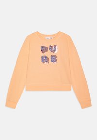 Persikofärgad bomulls sweatshirt med långa ärmar och ribbade muddar. Dekorativt paljetttryck med texten "PURE" i olika färger på framsidan.
