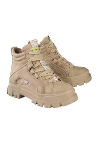 Bottines en daim beige avec des semelles en caoutchouc épaisses, des lacets marquants, des accents de logo et une languette distinctive avec une marque.