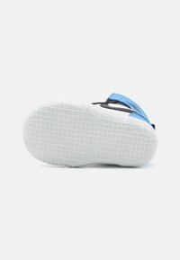 Schwarze und blaue Sandale mit strukturierter weißer Gummisohle. Verfügt über einen blauen Riemen und ein flexibles Design, ideal für den Freizeitgebrauch.