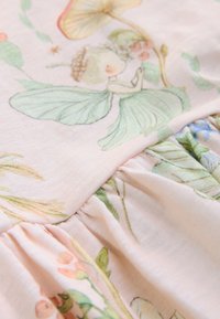 Világos rózsaszín szövet, melyen illusztrált tündér- és virágminták találhatók. Ráncolt varrások zöld levelekkel és pasztell árnyalatokkal. Puha tapintású.